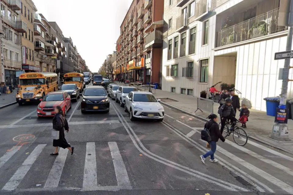 Google street view of Bedford Avenue in Brooklyn with pedestrians crossing a crosswalk and cyclist in the bike lane.
